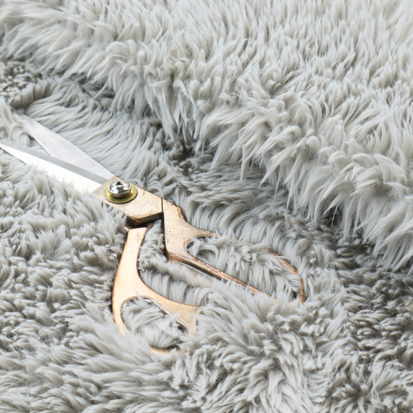 A cool-toned, light silver-grey high-pile faux fur fabric. It has a dense, plush texture characterized by soft, tousled fibres that create a cosy, shag-like appearance.