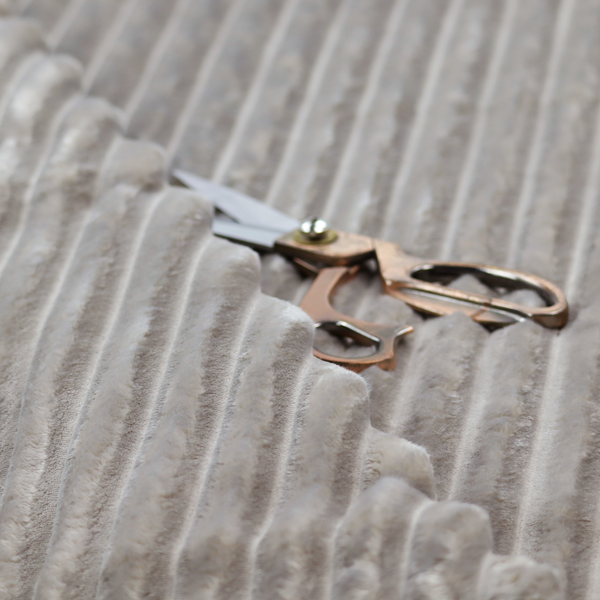 A grey textile featuring a repeating, vertical channel-tufted pattern that alternates between soft, high-pile bands and narrow, flat lines.