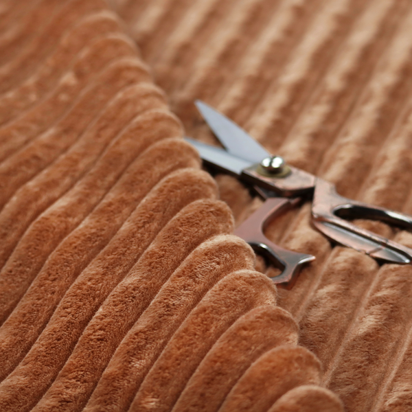 A tanned copper, vertically ribbed, channel-tufted plush fabric.