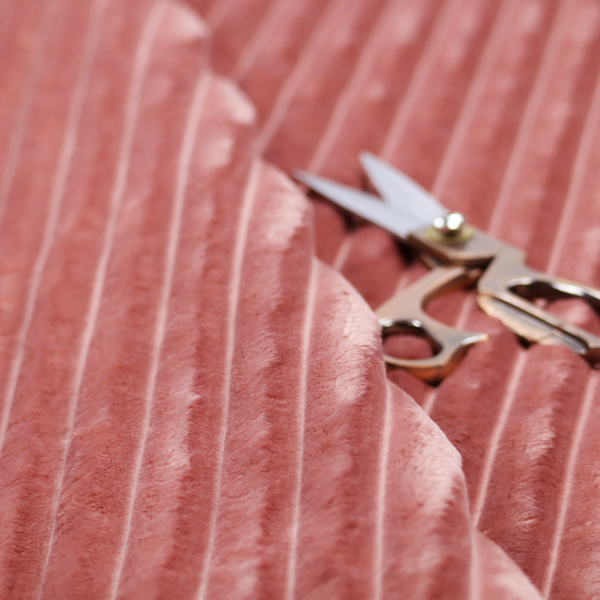 A pink, vertically ribbed, channel-tufted plush fabric.
