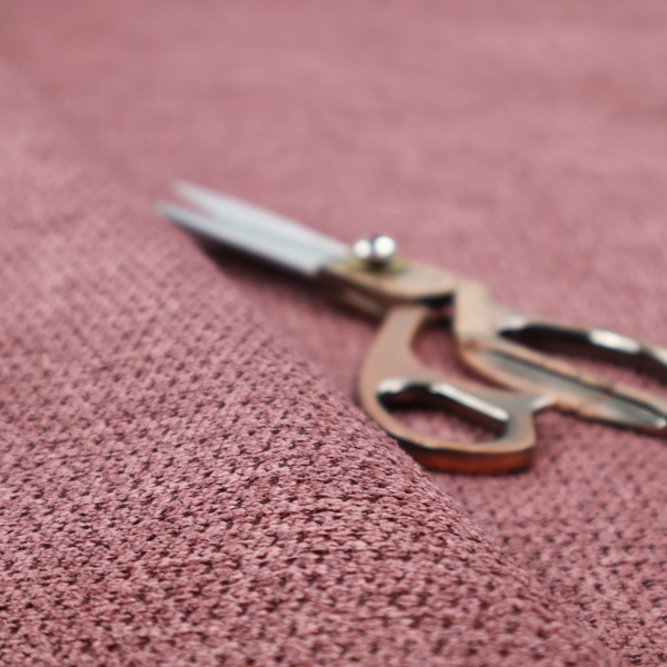 A textured fabric in a deep dusty rose or muted berry tone. The material features a tight, uniform weave with a distinct honeycomb-like structure. The colour is a rich, cool-toned mauve, achieved by blending darker plum threads with lighter pink fibres, creating a subtle weathered effect that adds depth and sophistication.