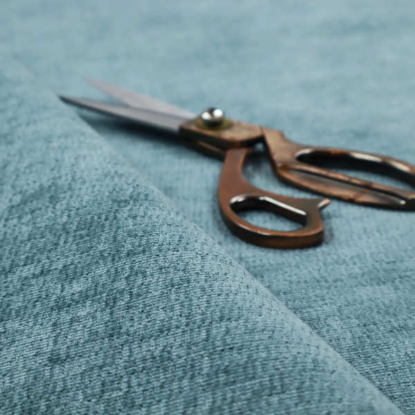 a teal or dusty blue fabric with a soft, weathered texture. The weave features a subtle horizontal grain with a plush, multi-tonal pile that blends shades of slate and ocean blue for a rich, tactile appearance.