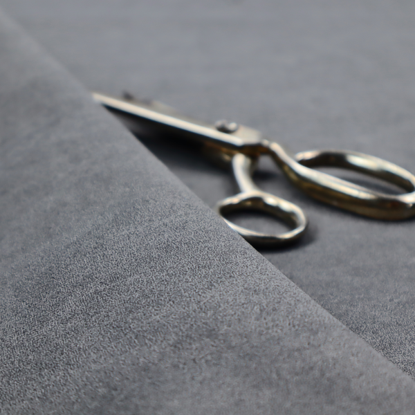 A charcoal or slate grey fabric with a rich, distressed felt-like texture. The surface features an intricate, stippled pattern of deep grey fibres mixed with lighter silver highlights. It is characterized by organic, vein-like distressing and light-coloured crackle lines, mimicking the look of weathered leather or heavy-duty industrial felt.