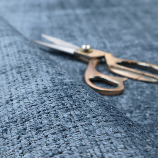 Scanno Weave upholstery fabric in a medium blue shade, featuring a detailed, woven texture with an interlocking grid pattern.