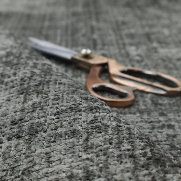 Scanno Weave upholstery fabric in a neutral grey shade, featuring a detailed, woven texture with an interlocking grid pattern.