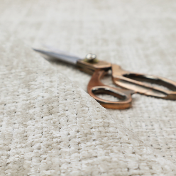 Scanno Weave upholstery fabric in a creamy off-white shade, featuring a detailed, woven texture with an interlocking grid pattern.