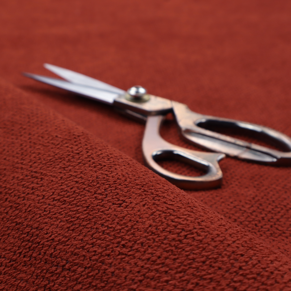 A waffle-knit or honeycomb-patterned weave, defined by a uniform, three-dimensional grid of raised, rounded textures. Its bold, warm terracotta or rust hue and matte finish provide a striking, cosy aesthetic. This structured, high-quality material is an excellent choice for statement upholstery, decorative accent cushions, or premium home textiles that require a blend of durability and timeless, earthy style.