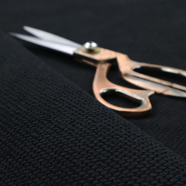 A premium midnight black waffle-knit fabric, showcasing a refined, dense, and uniform three-dimensional honeycomb texture.