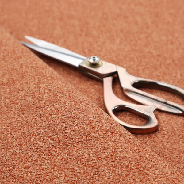 A Chamonix Water Repellent upholstery fabric in Orange. The material features a dense, multi-tonal rust orange basket weave texture with a durable, matte finish.