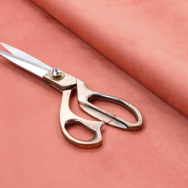 Annecy Water Repellent Velvet in Coral. The fabric features a dense, plush pile with a soft matte finish in a warm, vibrant pinkish-orange tone. This high-performance upholstery material offers a luxurious feel combined with a specialized water-resistant coating for enhanced durability and a fresh, modern look.