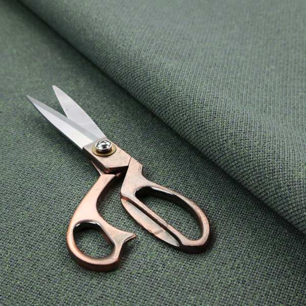 A charcoal or slate grey textile with a tight diagonal twill weave. The fabric is a multi-tonal blend, interlacing dark grey yarns with subtle, bright lime green flecks that provide a modern, heathered dimension.