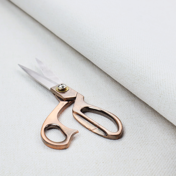A light-coloured, off-white fabric with a fine, textured weave.