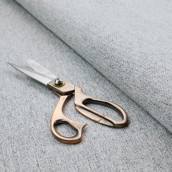 A light grey upholstery fabric with a dense, speckled textured weave.