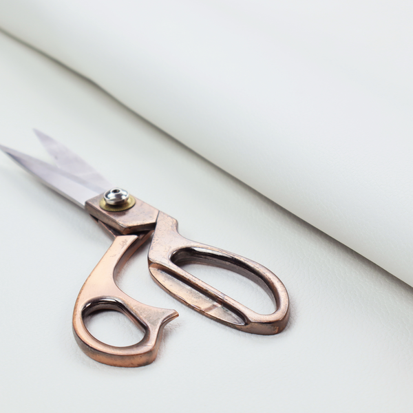 A bright white faux leather fabric featuring a subtle, pebbled texture.