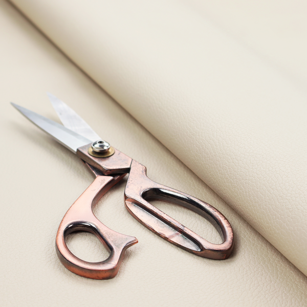 Boston Faux Leather Upholstery Fabric in a soft beige colour, showcasing a fine pebbled texture.