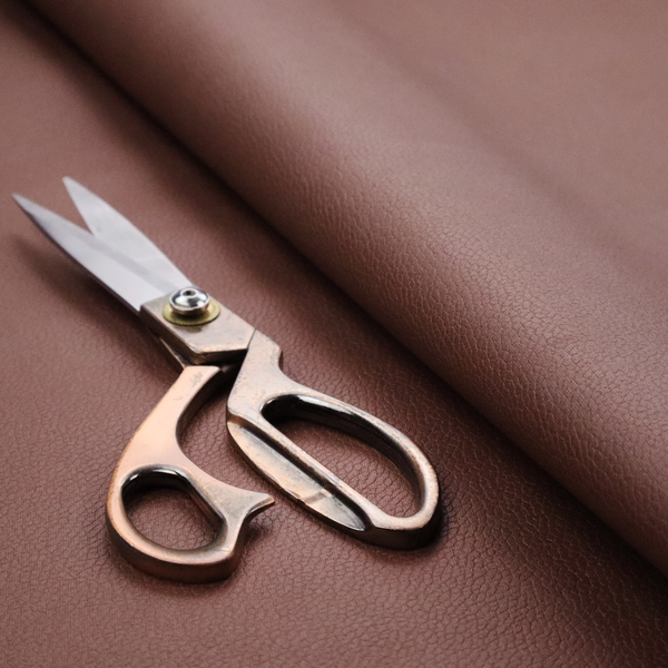 Boston Faux Leather Upholstery Fabric in a deep reddish-brown colour, showcasing a fine pebbled grain texture.