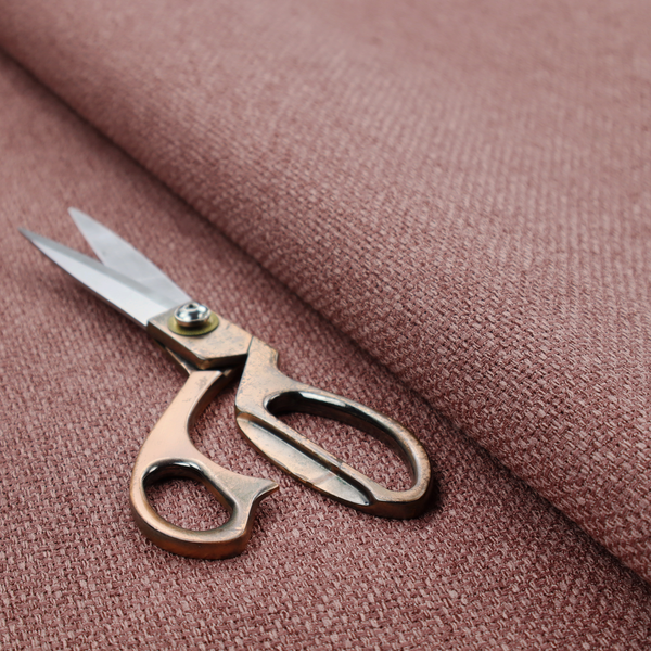 A dusty rose or mauve fabric featuring a distinct, tightly woven grid texture. The material showcases a multi-tonal, basket-weave style pattern with blended pinkish-brown and muted rose threads, creating a soft, sophisticated, and matte finish across the entire surface.