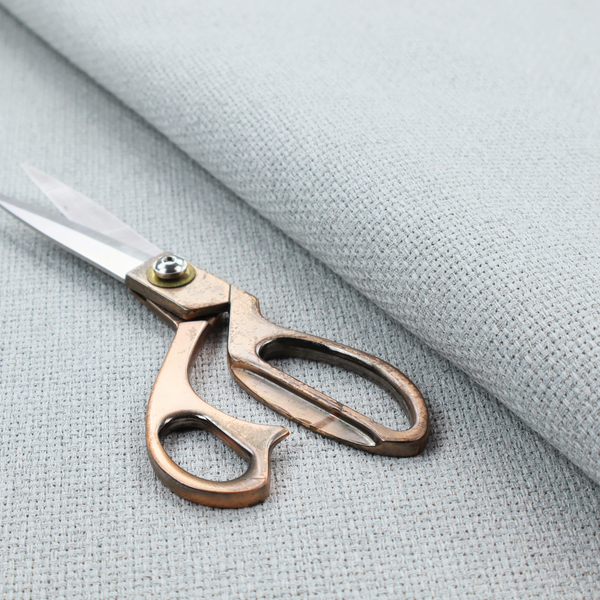 A very light ice-grey or tinted white fabric featuring a distinct, tightly woven grid texture. The material showcases a multi-tonal, basket-weave style pattern with blended pale silver and crisp off-white threads, creating a bright, minimalist, and matte finish across the entire surface.