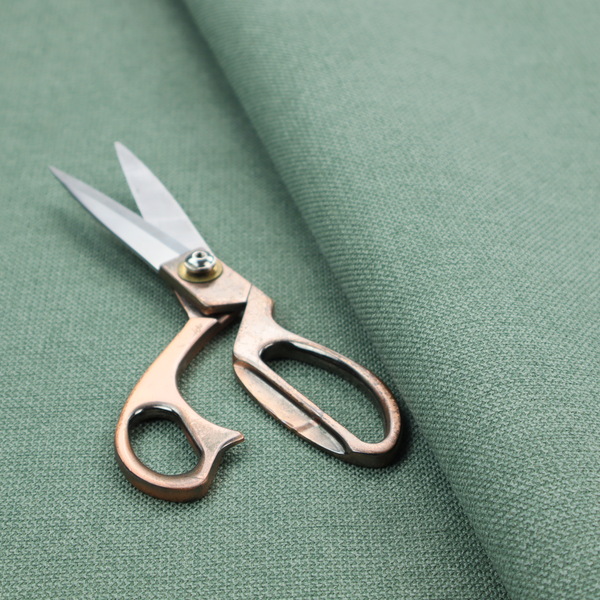 A textured sage or mint green fabric with a tight, uniform weave.