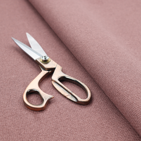 A textured dusty pink fabric with a tight, uniform weave.