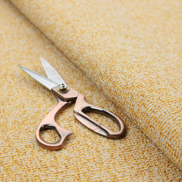 A textured mustard yellow and off-white woven upholstery fabric.