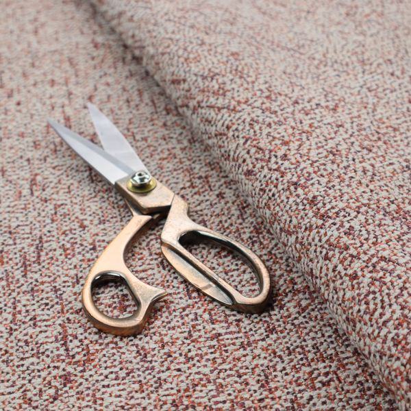 A textured rust red and beige woven upholstery fabric.