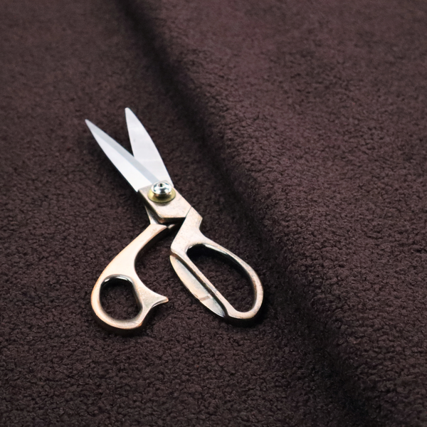 A textured dark espresso brown or deep plum bouclé upholstery fabric.