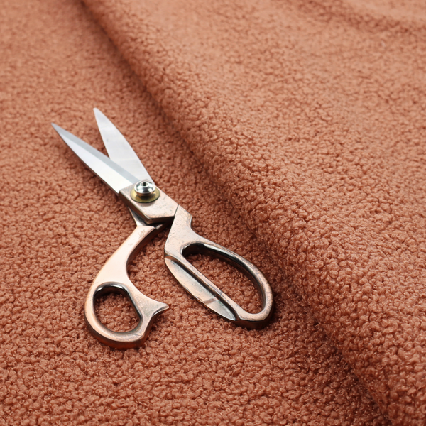 A terracotta or rust-orange boucle fabric texture.