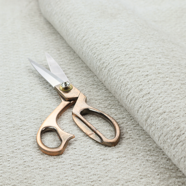 A swatch of light grey, textured upholstery fabric.