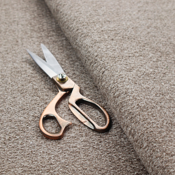 A swatch of taupe, heavily textured upholstery fabric.