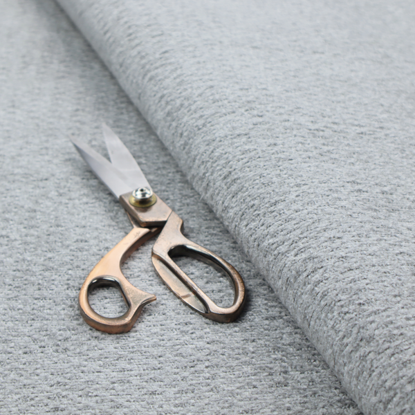 A textured light grey upholstery fabric.