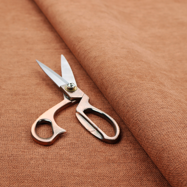 A finely textured weave in a bright ginger, amber, or light rust shade. The material features a subtle heathered look with finely blended threads of warm orange and darker neutral undertones throughout.