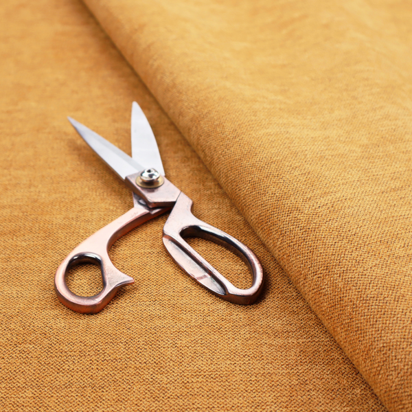 A finely textured weave in a rich mustard yellow or golden-amber shade. The material features a subtle heathered look with finely blended threads of warm yellow and darker neutral undertones throughout.