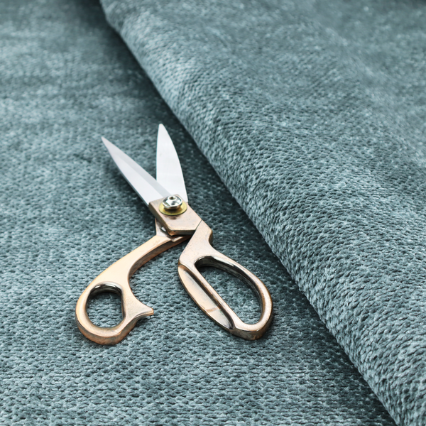 A cool, muted blue or slate-toned upholstery fabric. It features the same signature dense, uniform, boucle-style weave as the previous samples, characterized by small, looped, and nubby yarn fibres that create a soft and tactile surface.