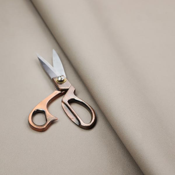 A solid taupe-coloured Hallstatt faux leather fabric texture with a smooth, fine finish.