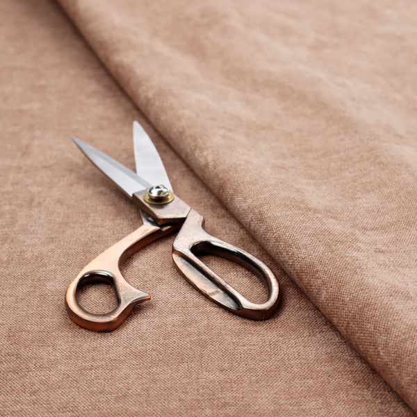 A textured, warm peach or terracotta-coloured woven upholstery fabric.