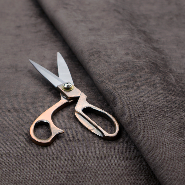 A textured, dark charcoal grey or brown-grey woven upholstery fabric.