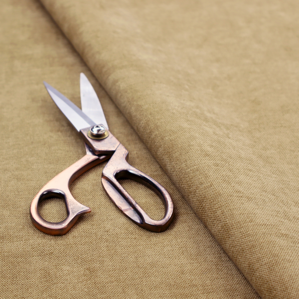 A textured, light brown or camel-coloured woven upholstery fabric.
