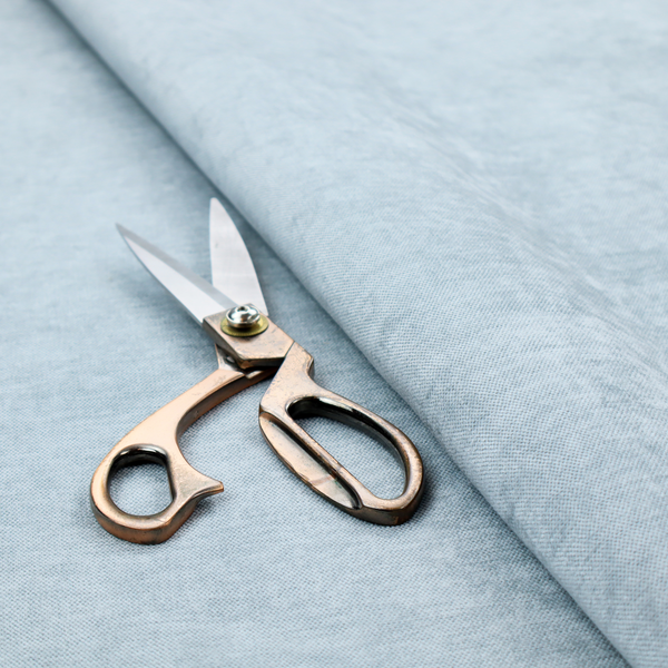 A textured, light blue or pale sky blue woven upholstery fabric.