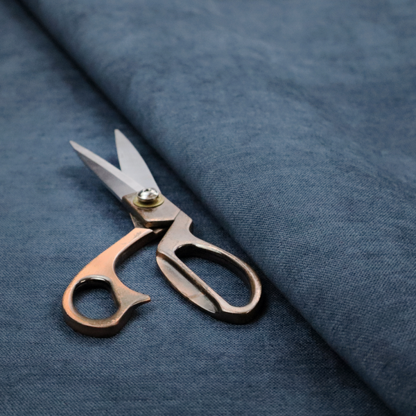 A textured, dark denim blue or navy blue woven upholstery fabric.