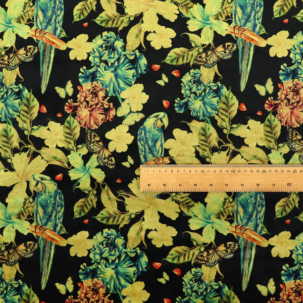 A repeating fabric pattern featuring blue and green parrots, butterflies, and large tropical flowers on a black background.