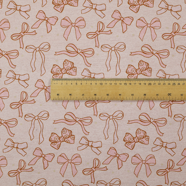 This fabric includes different shapes and styles of pink bows on a pink background.