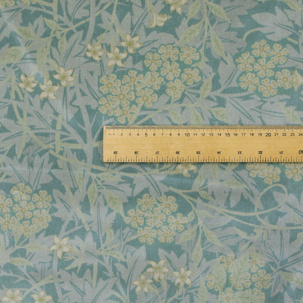 Muted green textile print with a complex, repeating botanical motif. The design features tightly packed five-petal flower clusters and delicate willow-like leaves in shades of dusty sage, teal, and pale lime green.