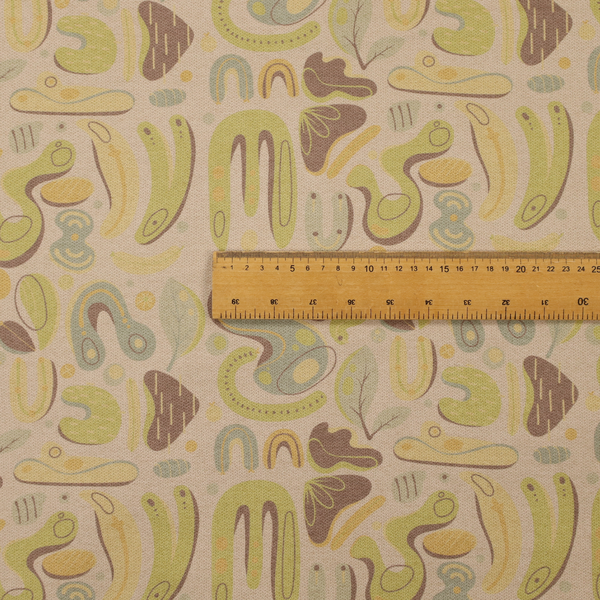 An abstract repeating pattern on a beige fabric background, featuring organic, amoeba-like shapes in earthy tones of olive green, muted yellow, and light brown. The design includes various fluid forms: U-shapes, elongated ovals, leaf-like outlines, and speckled pods. Some shapes are solid, while others contain interior lines, dots, or smaller concentric forms, creating a playful, mid-century modern or retro aesthetic with a soft, matte textile texture.