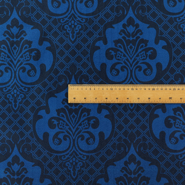 The design features large, ornate floral medallions and scrolling acanthus leaves in a bright royal blue shade, set against a deep navy background. A fine diagonal lattice grid fills the space between the motifs, and the material displays a clear woven texture that adds structural depth and a subtle sheen to the tonal blue design.