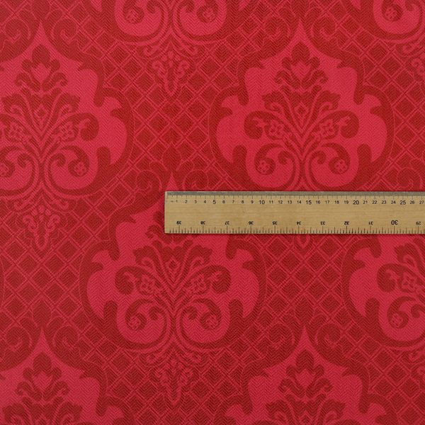 The design features large, ornate floral medallions and scrolling acanthus leaves in a slightly lighter shade of red, creating a tonal, high-contrast effect. A fine diagonal lattice grid fills the background between the motifs, and the material shows a clear woven texture that adds depth and a traditional feel to the design.