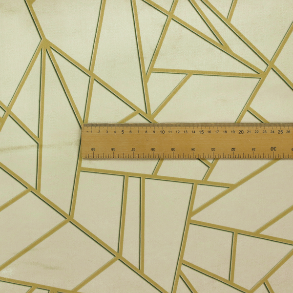 A close-up of a luxurious fabric featuring a geometric, fractured glass pattern. The design consists of irregular, sharp-angled polygons in a pale sage green or muted seafoam hue. These shapes are separated by thick, shimmering gold metallic lines that appear slightly recessed or embossed, creating a high-contrast, mosaic-like effect.