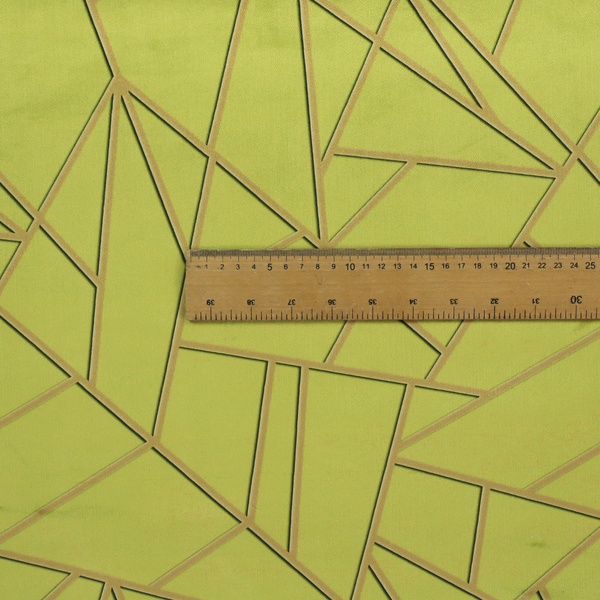 A close-up of a luxurious lime or chartreuse green fabric featuring a fractured, geometric mosaic pattern. The vibrant, matte background is segmented by a network of recessed metallic gold lines that form sharp, irregular polygons. This "shattered-glass" effect combines a high-energy, citrus-toned base with shimmering, Art Deco-inspired gold linework for a bold and architectural look.
