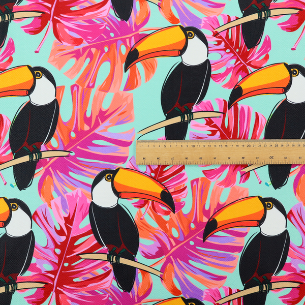 This fabric features vibrant, tropical-themed repeating pattern showcasing toucans and exotic foliage.