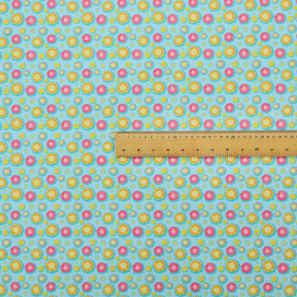 Light blue fabric featuring an all-over repeating pattern of vibrant pink and gold floral motifs interspersed with small yellow dotted accents.